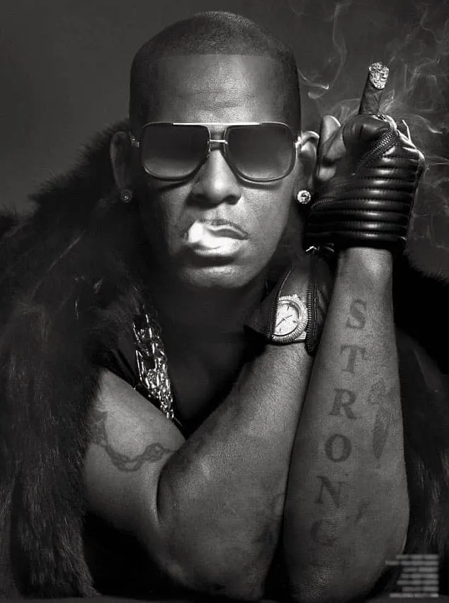 R. Kelly has tattoos on both arms.