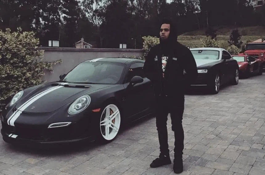 Chris Brown posing next to his 2016 Porsche 911 Turbo S.