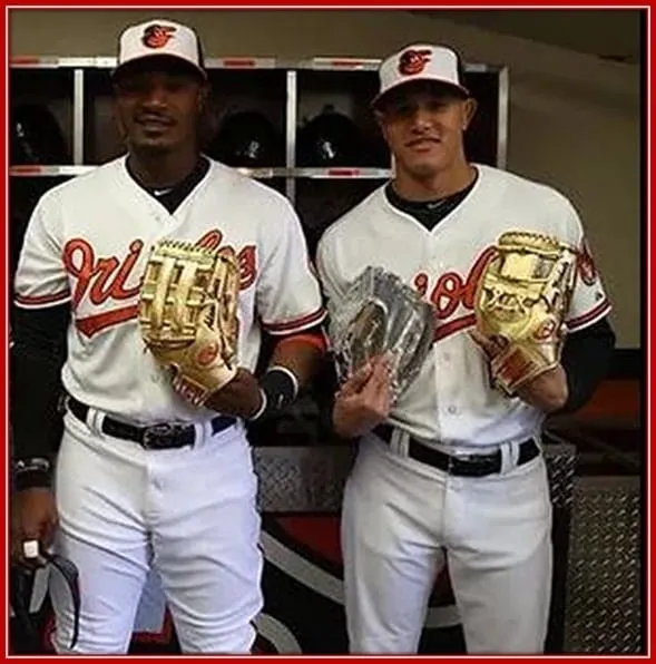 Behold Manny Machado as he Holds his Double Awards, the Gold and Al Platinum Glove.