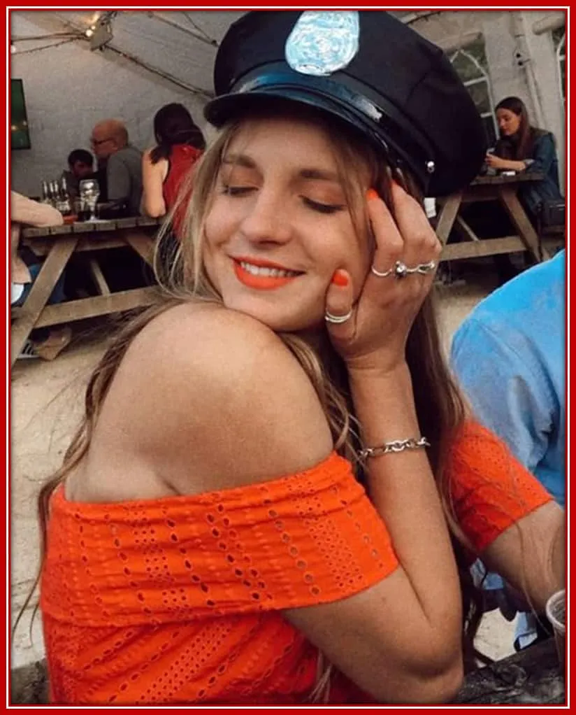 Behold Tom's childhood sweetheart, beautiful Elle, posing with a police cap to the camera.