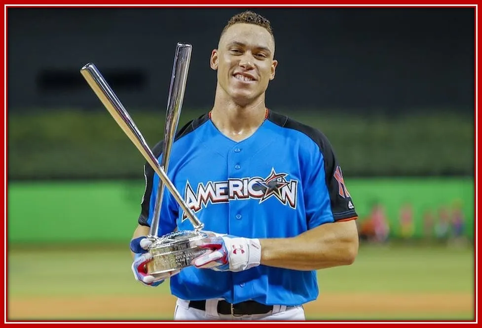 The Baseball Athlete Aaron Judge posing with the Home Run Derby Award.