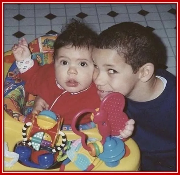 Behold Lamelo Ball as a Baby in the Walker, Being Hugged by one of his Brothers.